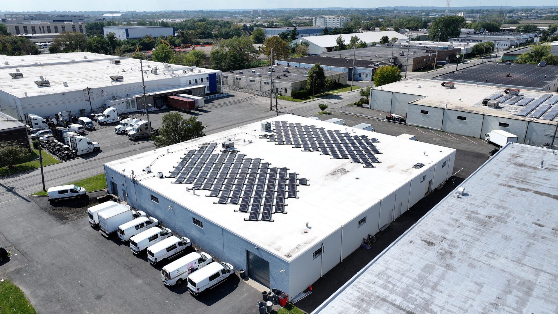 Warehouse rooftop solar arrays, aerial view