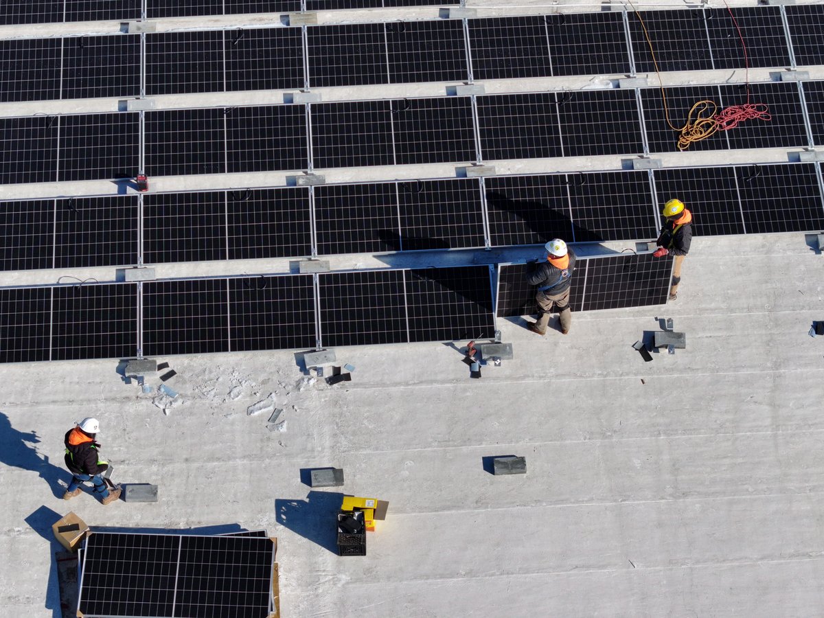 Drone view of the installation crew working on a rooftop array