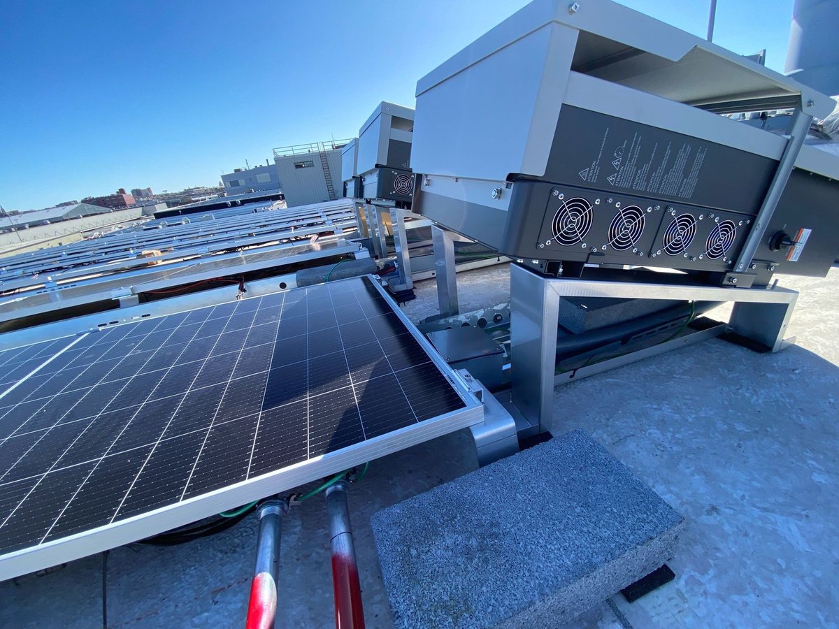 Inverter mounted beside a rooftop solar array