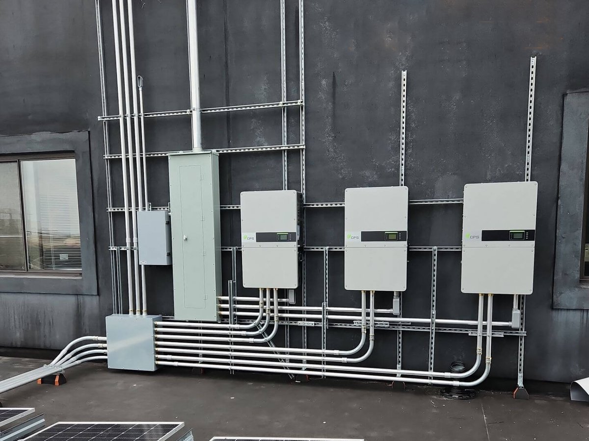 Inverters and conduit runs mounted on a rooftop wall
