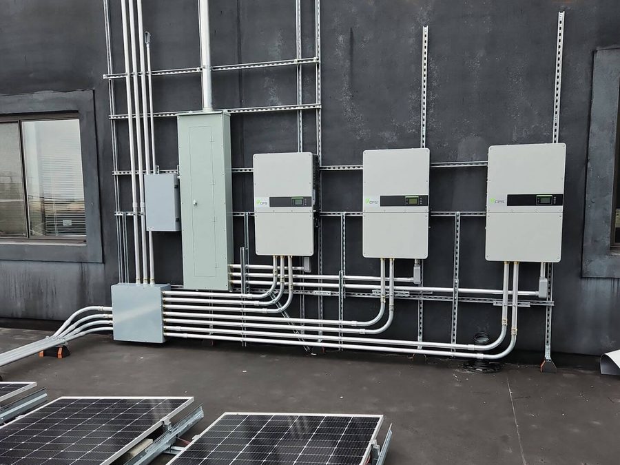 Inverters and conduit mounted on a rooftop wall
