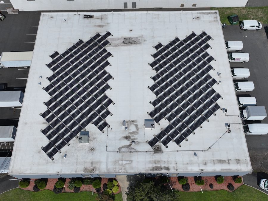 Top-down drone view of a New Jersey warehouse roof with two solar arrays