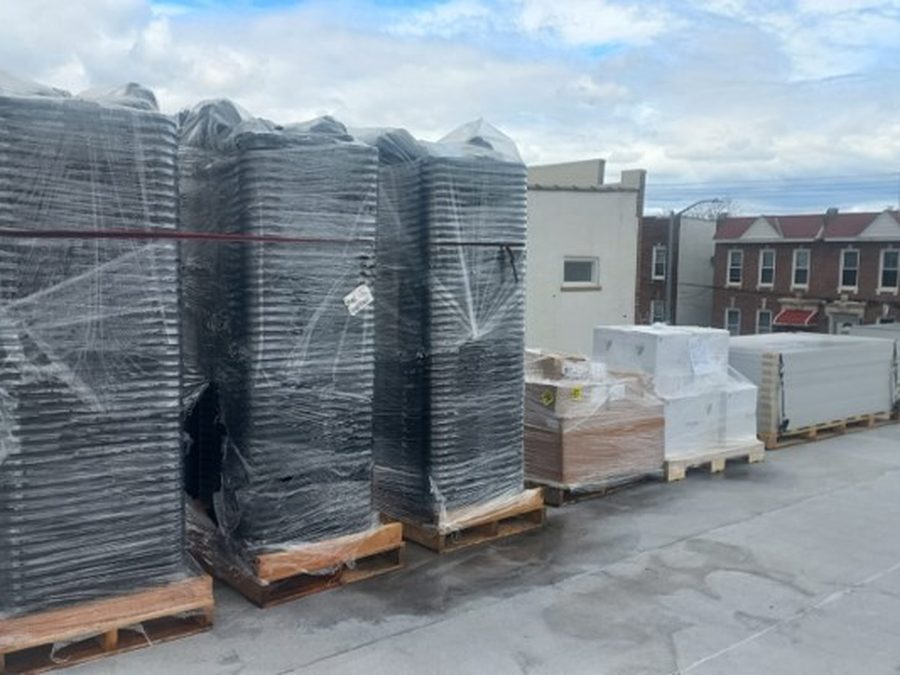 Palletized solar modules staged on a rooftop before installation
